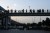 Daily commuters of Delhi Metro are seen coming out of Metro station, on a raised walkway