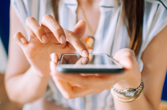 A close-up view of a young woman in casual attire using a mobile phone, used in a post about buy now pay later startup BillEase