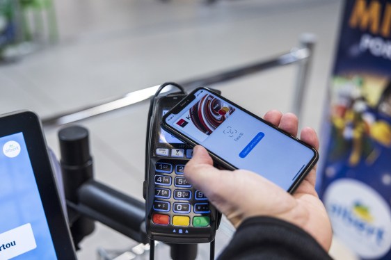 A customer uses Apple pay mobile payment at a contactless payment terminal