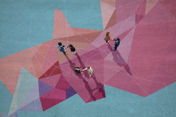 Group of young adults, photographed from above, on various painted tarmac surface shaking hands to close a deal.