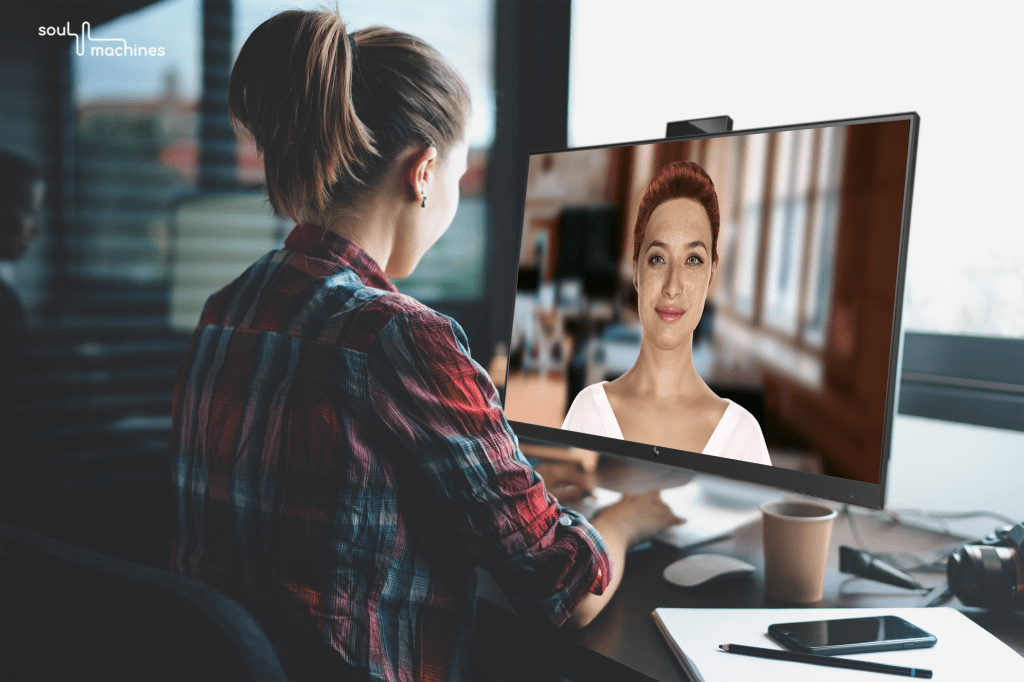 woman sits at computer and interacts with autonomously animated digital person created by Soul Machines