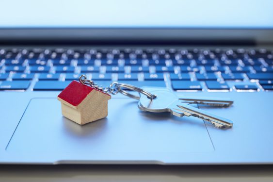 Image of a key ring with a small house and keys on laptop computer
