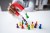 Person using a magnet to attract pawns on a table representing customers