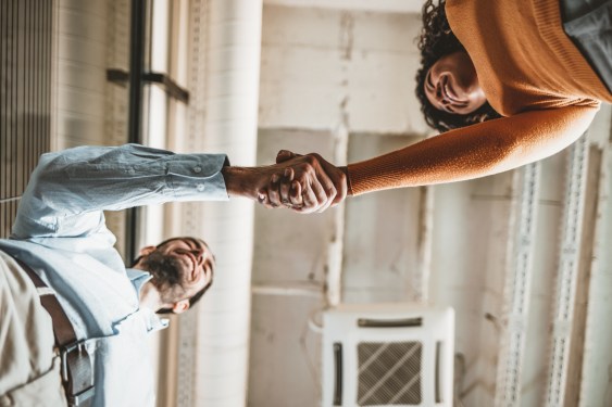 Two people shaking hands in an office, used in an article about Employment Hero, a human resources platform