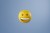 Computer graphics of yellow smiling round emoji emoticon isolated on pastel blue background. Happy face emoticon.