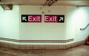 Two Subway Exit Signs Pointing in Opposite Directions