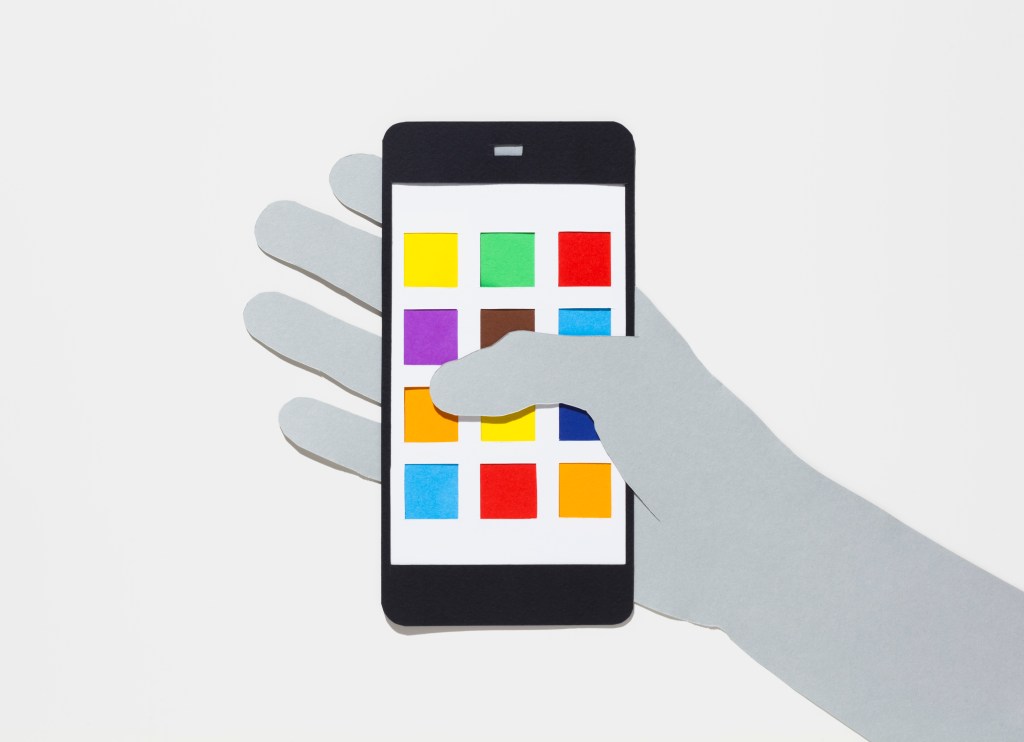 Image of a hand holding a smartphone with multicolored app squares.