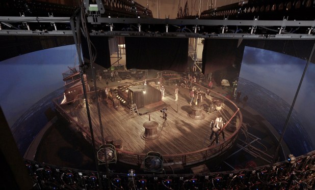 Overhead view of a virtual production facility filled with cast and crew.