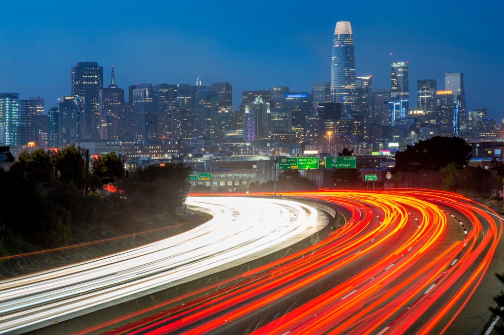 A photo of traffic heading in and out of San Francisco on highway 101 with the city skyline in the background.