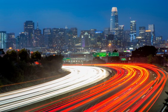 A photo of traffic heading in and out of San Francisco on highway 101 with the city skyline in the background.