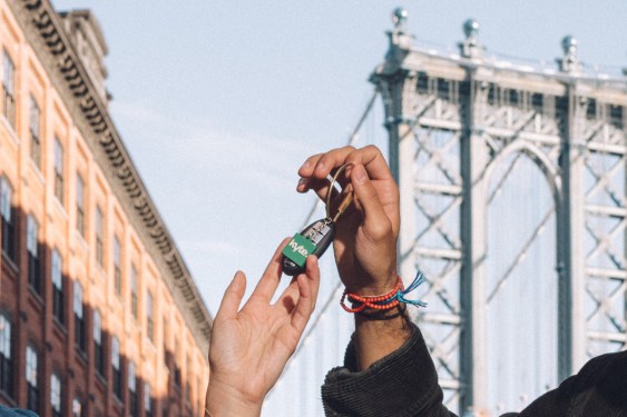 Kyte courier hands keys of rental car to customers in front of Brooklyn Bridge