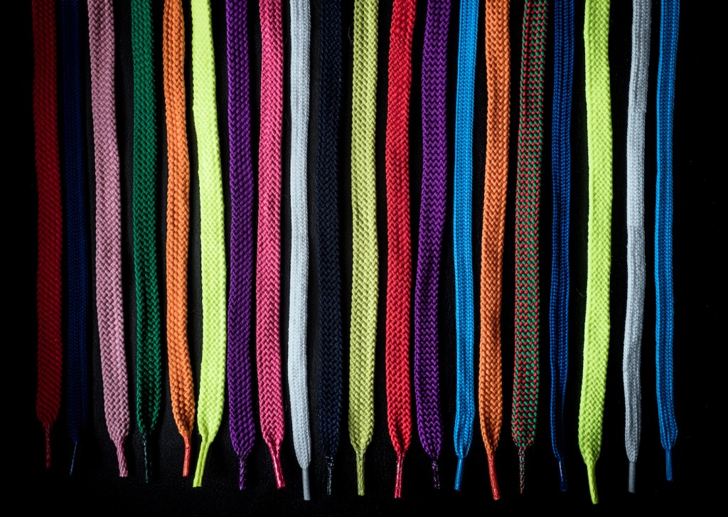Close-Up Of Multi Colored Shoelaces Against Black Background
