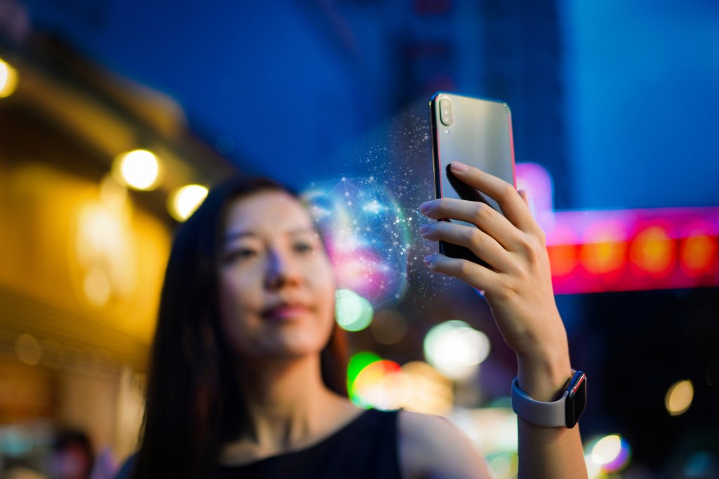 Woman logs onto iPhone using Face ID.