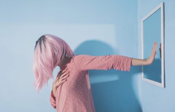 Woman showing hand to mirror at home