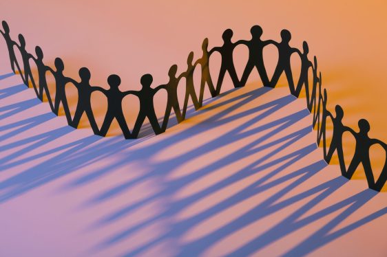 Multiple Paper Figures Joining Together As Team, Union, Family or Network