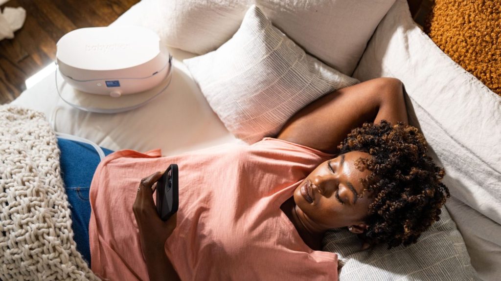 Woman laying down with a breast pump