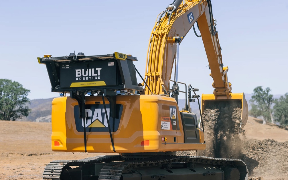 An autonomous excavator lifting dirt from the ground