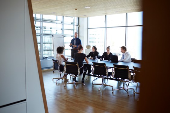 Large group of corporate business people in a meeting in a modern conference room.