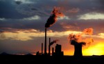 Coal power station with smoking chimneys in sunset with cloudy sky, industrial landscape