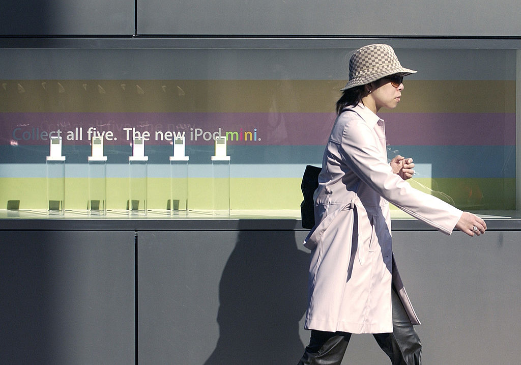 JAPAN - NOVEMBER 24: A woman walks by an iPod Mini display outside the Apple Store in Tokyo's Ginza district Wednesday, November 24, 2004. In Japan, home to four of the five top electronics companies by sales, advance orders made Apple Computer Inc.'s iPod mini the top-selling portable player three weeks before its July 24 release. It still is. (Photo by Michael Caronna/Bloomberg via Getty Images)