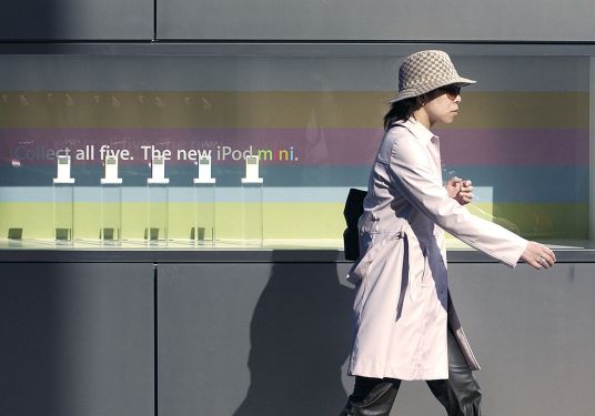 JAPAN - NOVEMBER 24: A woman walks by an iPod Mini display outside the Apple Store in Tokyo's Ginza district Wednesday, November 24, 2004. In Japan, home to four of the five top electronics companies by sales, advance orders made Apple Computer Inc.'s iPod mini the top-selling portable player three weeks before its July 24 release. It still is. (Photo by Michael Caronna/Bloomberg via Getty Images)