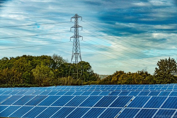 A solar farm beneath a pylon