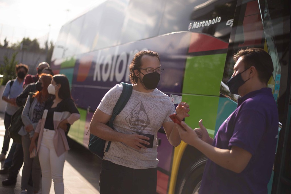 Bus attendant checks in Kolors passenger for intercity bus ride in Mexico
