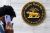 man on mobile phone walking past Reserve Bank of India sign