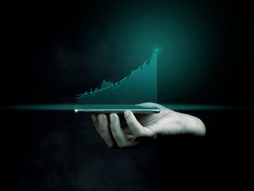 Businessman holding a smart phone and showing holographic graphs and stock market statistics gain profits. Concept of growth planning and business strategy. Display of good economy form digital screen.