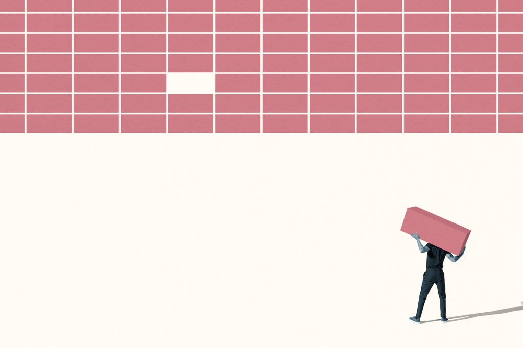 Rear view of young man carrying pink block while standing on white background; building software company
