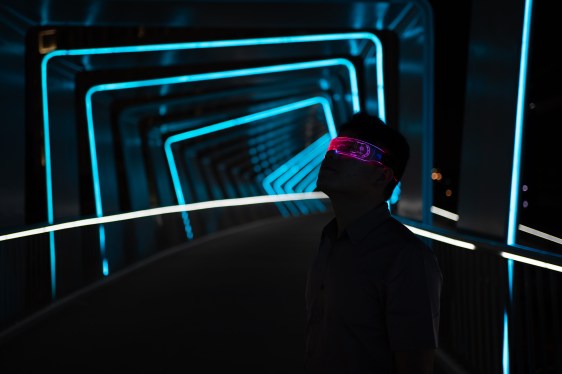 Image of a man using virtual reality glasses amid lights.