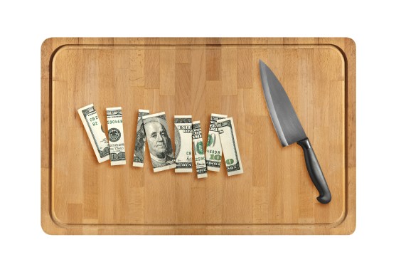 Knife and sliced hundred dollar on Wooden cutting board. isolated on white background.