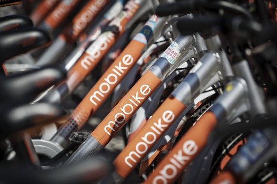 Mobike bikes stacked in a row on a bike rack.