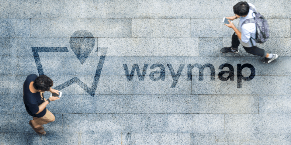 Waymap logo on ground as two men walk by using smartphones