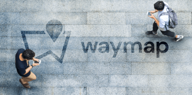 Waymap logo on ground as two men walk by using smartphones