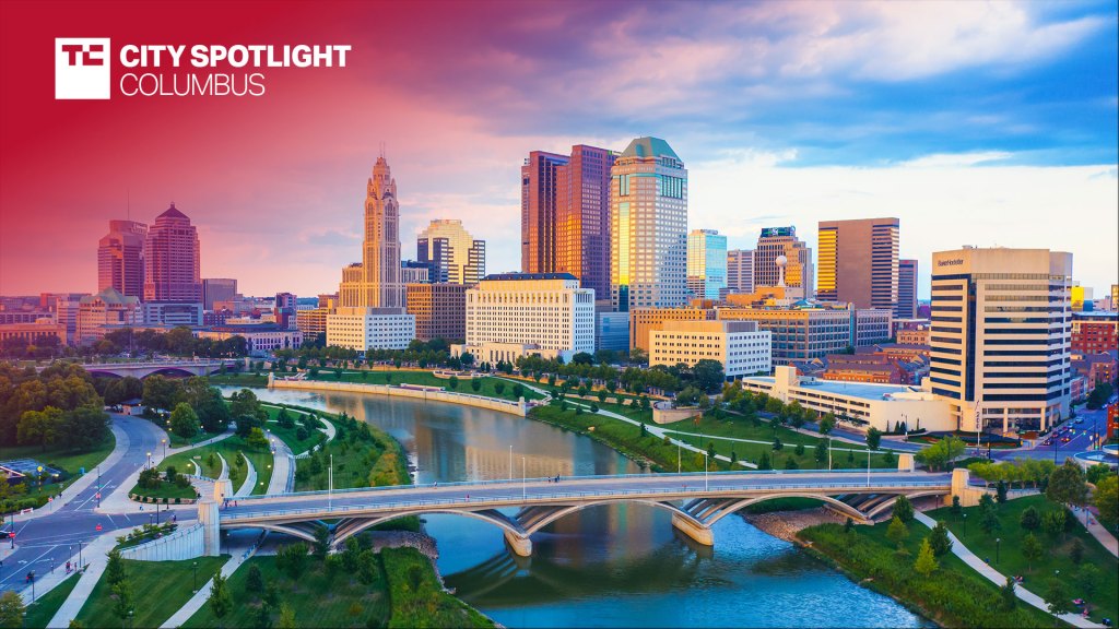 Aerial view of Downtown Columbus Ohio with Scioto river. Text overlay reads "TC City Spotlight: Columbus"