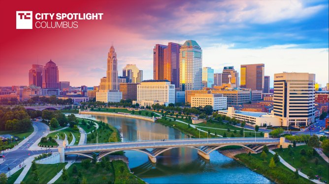 Aerial view of Downtown Columbus Ohio with Scioto river. Text overlay reads "TC City Spotlight: Columbus"