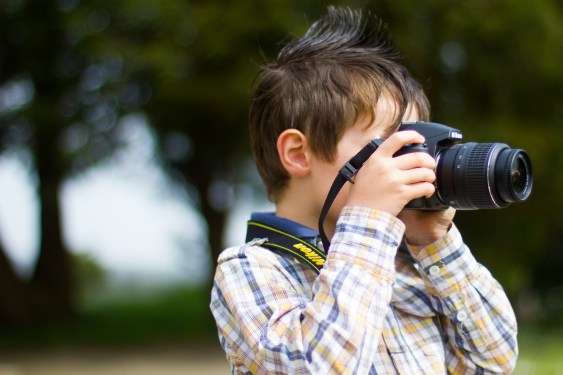 Boy shoots a picture with a Nikon camera