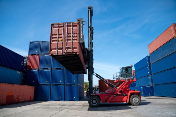 Industrial logistic forklift truck containers had lifted the container box and hold in the container yard.