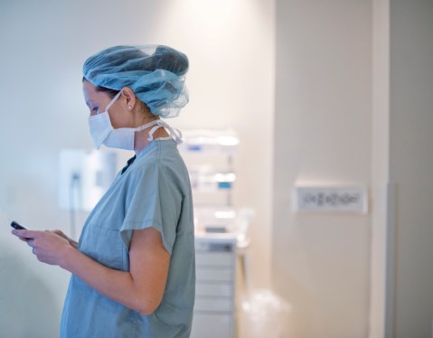Nurse using smartphone, used in post about healthcare startup Carepatron