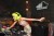 A DJ with lime green hair performs at a SoundCloud event. You can see a SoundCloud logo in the background.