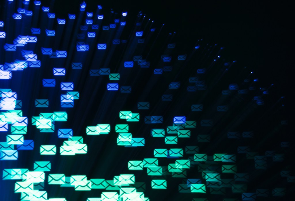 Blue and green email envelopes floating on a black background