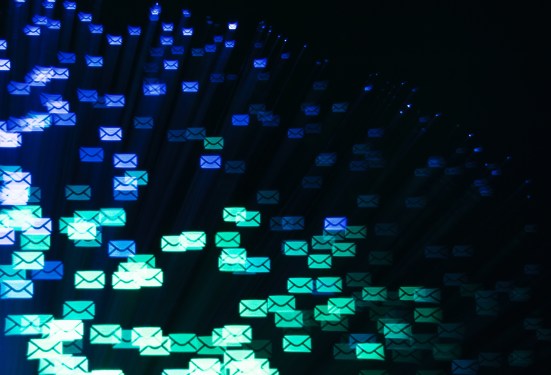 Blue and green email envelopes floating on a black background