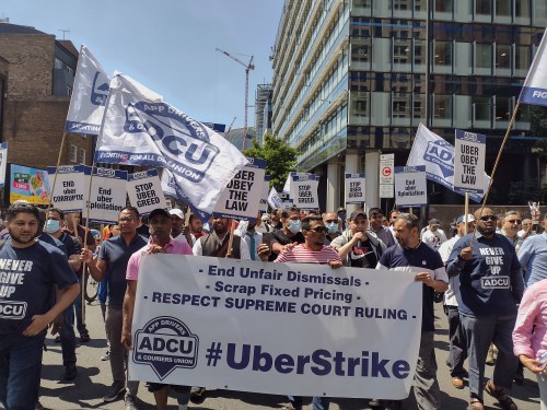 Uber drivers holding up signs that say #uberstrike
