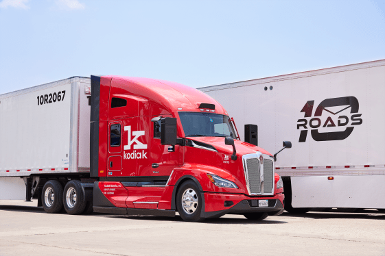 Red heavy duty truck with Kodiak Robotics logo in front of freight with 10 Roads logo