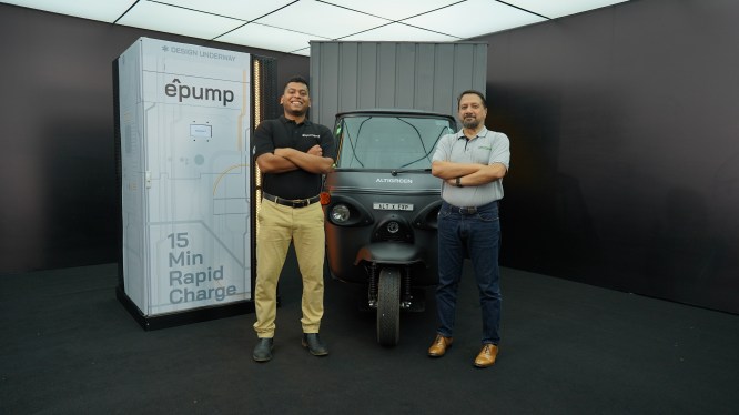 two men posing in front of charging infrastructure and electric three-wheel cargo vehicle