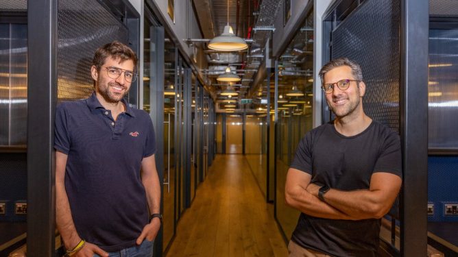 two men standing in office hallway