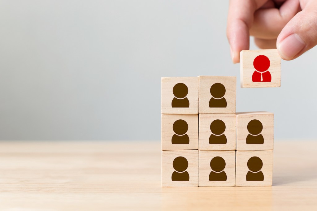Cropped Hand Stacking Toy Blocks On Table, used in a post about recruitment automation platform Kula