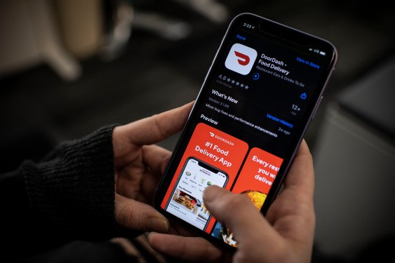 A journalist scrolling through the DoorDash app on their phone.