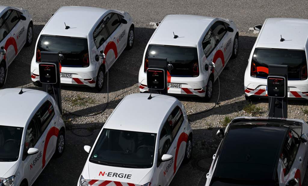 A row of electric cars lined up and charging in the street